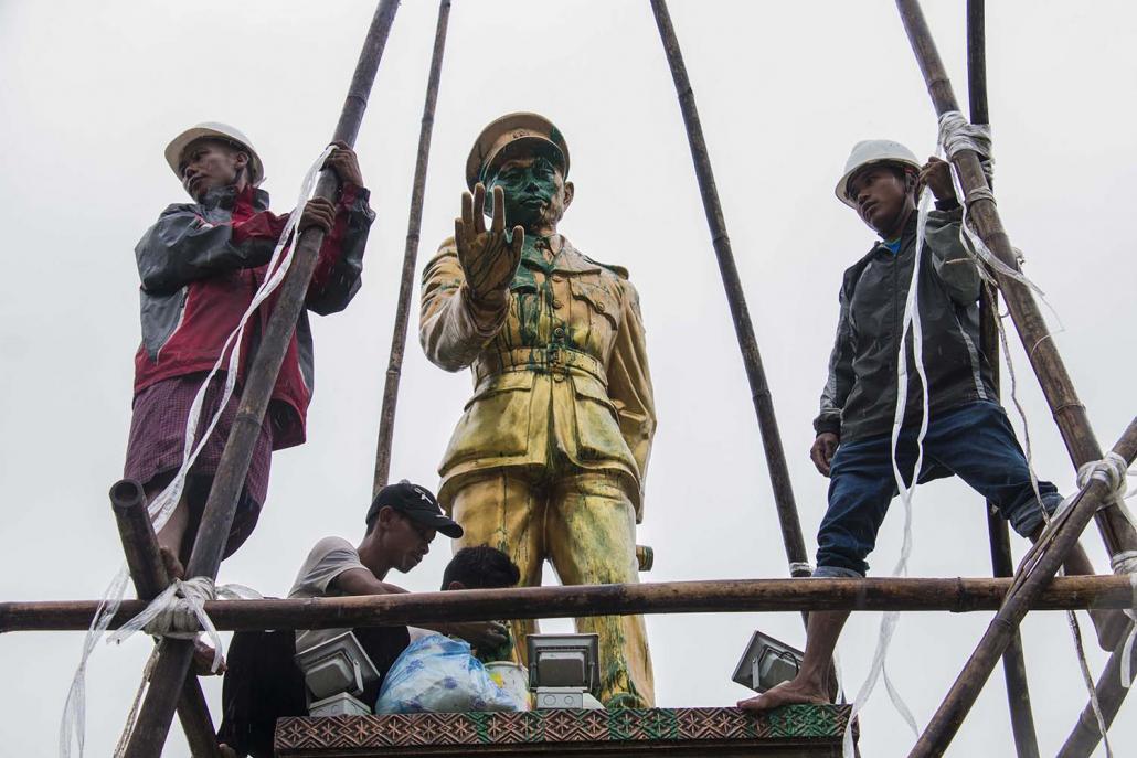 Workers clean a statue of Myanmar independence hero General Aung San in Myitkyina, the capital of Kachin State, after it was defaced with paint. (AFP)