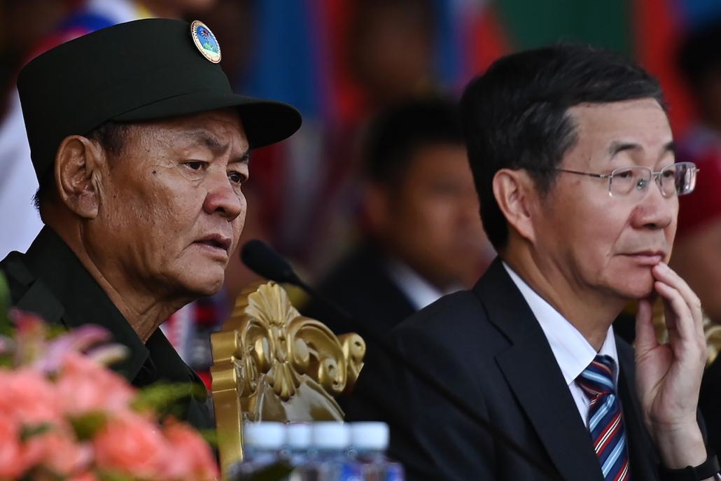 United Wa State Army leader Bao Youxiang (left) and China's Foreign Ministry's special envoy for Asian Affairs Sun Guoxiang watch a military parade, to commemorate 30 years of a ceasefire signed with the Myanmar military. (AFP)