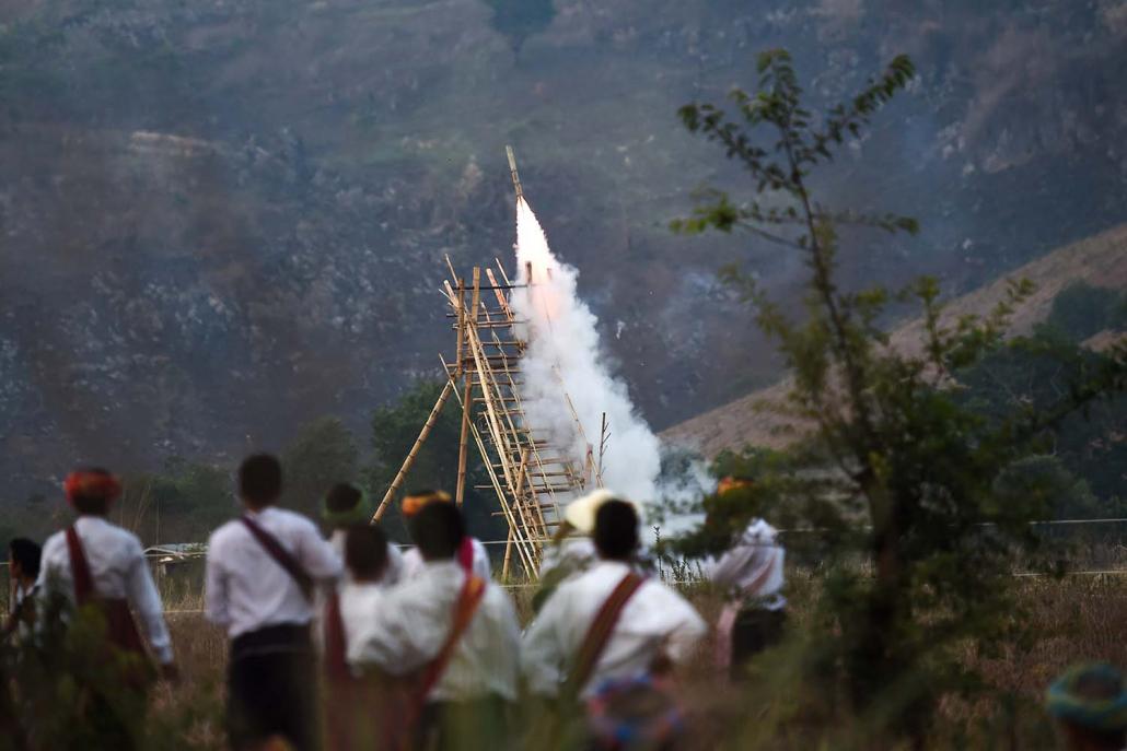 Festivalgoers watch the launch of a homemade rocket. (AFP)