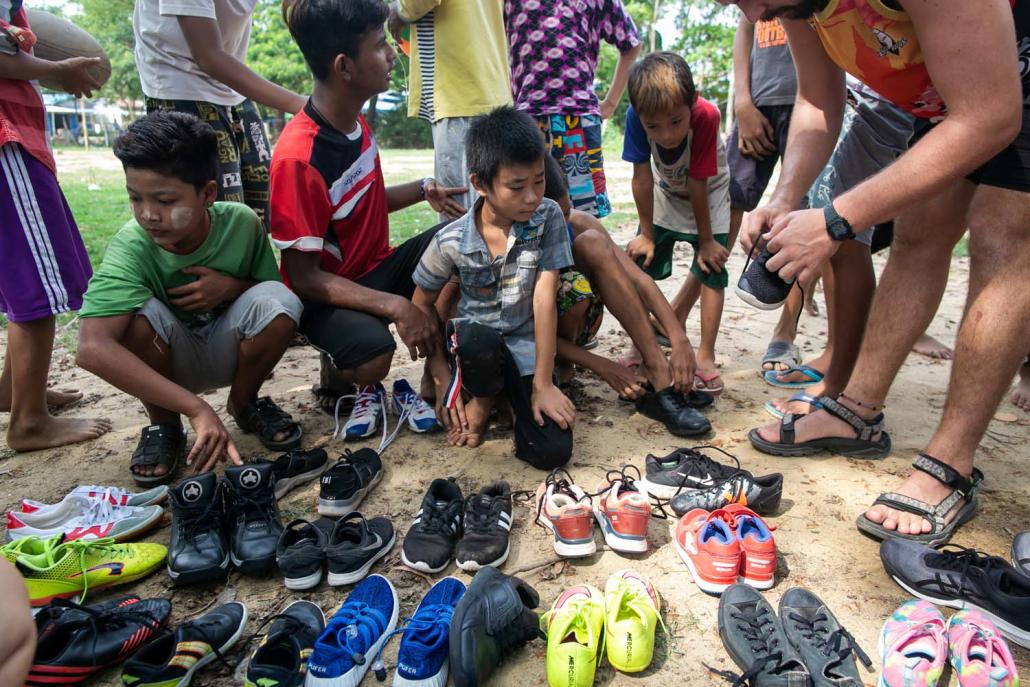 Players from the Little Dragons rugby team choose pairs of donated secondhand shoes for themselves. (AFP)