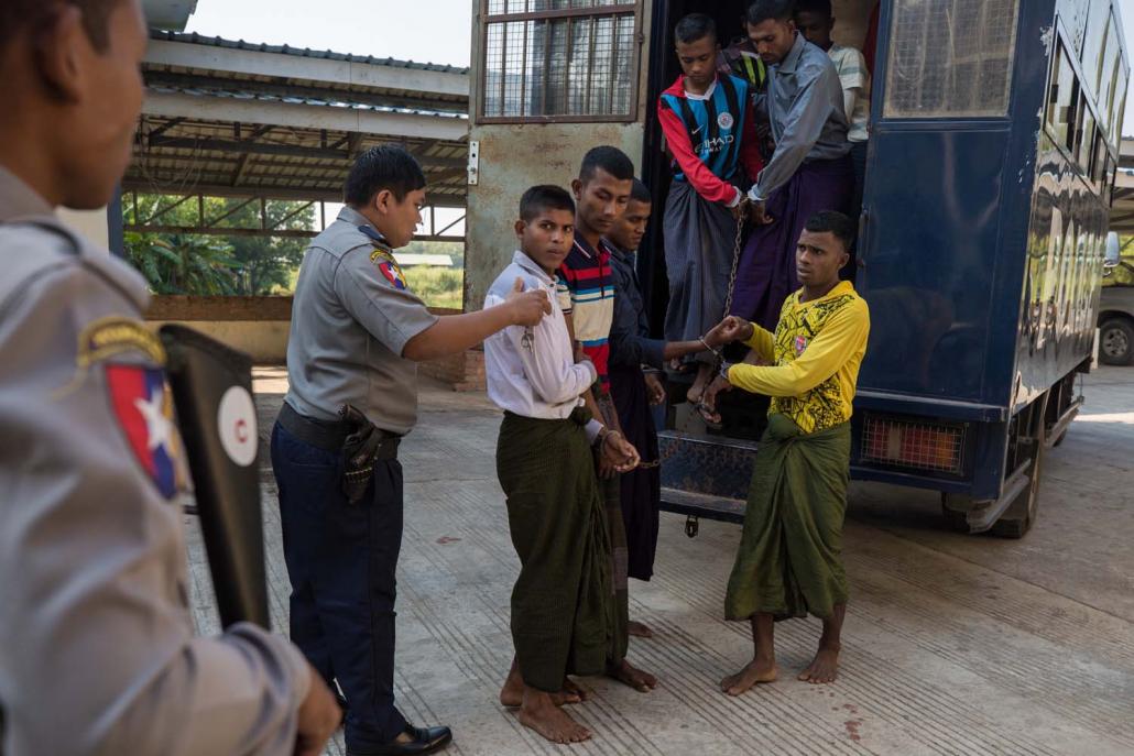 Rohingya detainees step out of a police van on arriving at Pathein Township Court on December 11. (AFP)