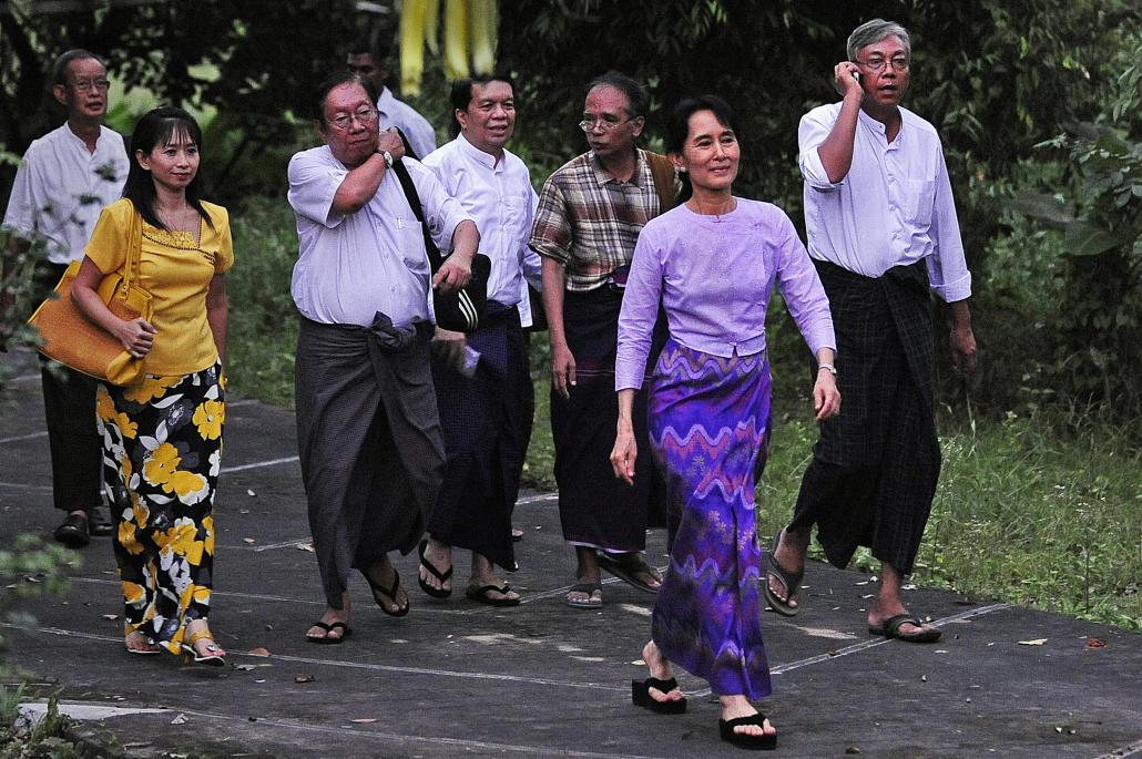 ၂၀၁၀ ခုနှစ်၊ နိုဝင်ဘာ ၁၃ ရက်နေ့က နေအိမ်အကျယ်ချုပ်မှ လွတ်မြောက်လာသည့် ဒေါ်အောင်ဆန်းစုကြည်အား ဦးထင်ကျော်နှင့်အတူ ၎င်း၏ ခြံတံခါးဝတွင် တွေ့ရစဉ်။ ဓာတ်ပုံ- အေအက်ဖ်ပီ