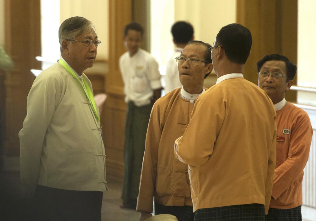 ပြည်ထောင်စုလွှတ်တော်မစတင်မီ အမျိုးသားဒီမိုကရေစီအဖွဲ့ချုပ် လွှတ်တော်ကိုယ်စားလှယ်များနှင့် စကားပြောနေသည့် ဦးထင်ကျော်။ ဓာတ်ပုံ- အေအက်ဖ်ပီ