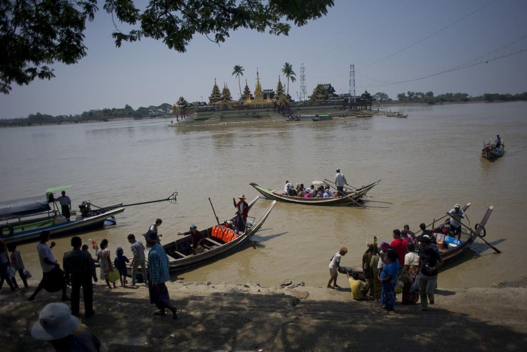 People ride ferries to cross a river to go to the Kyaik Mhaw Wunn Pagoda on the outskirts of Yangon. (Ye Aung Thu / AFP)