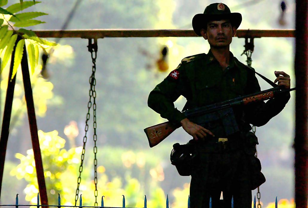 A soldier stands outside Aung San Suu Kyi's home in Yangon's University Avenue during her house arrest. (AFP)