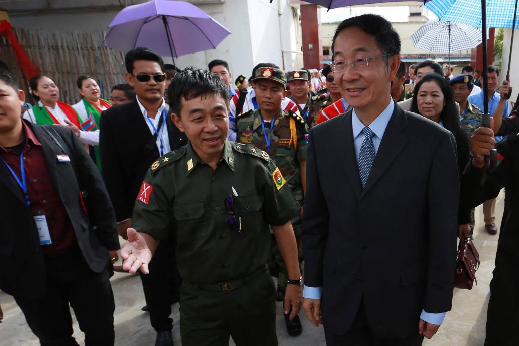 Kachin Independence Army leader General Gun Maw, left, walks with Chinese Special Envoy Sun Guoxiang as leaders and representatives of various ethnic armed groups arrive for the opening of a four-day conference in Mai Ja Yang. (AFP)