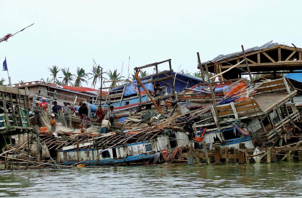 Survivors stand on houses destroyed by Cyclone Nargis in the devastated area of Hainggyi Kyun, Ayeyarwady Region, on May 11, 2008. (AFP)