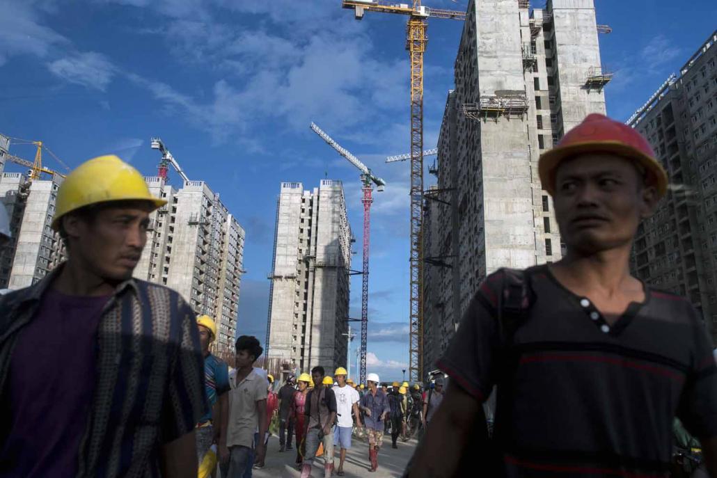 Workers leaving a low-cost housing construction site on the outskirts of Yangon. (Ye Aung Thu / AFP)