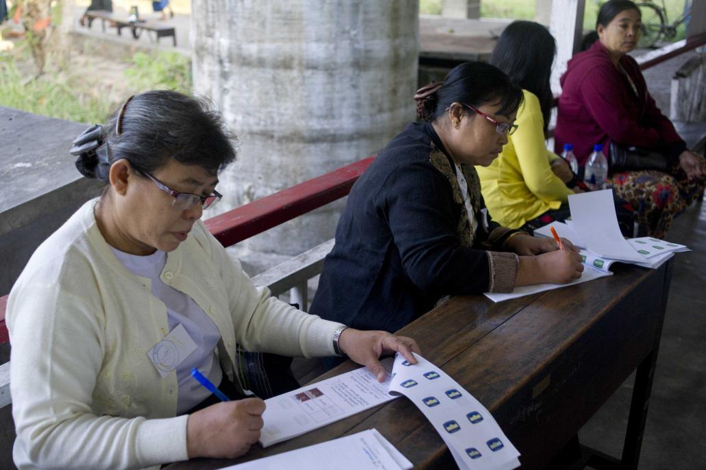 Volunteers prepare at a polling station in Yangon on December 27, 2014, for the city's first municipal vote in six decades. Only 400,000 out of the city's 5.1 million residents were eligible to vote and turnout was barely 25 percent. (AFP)