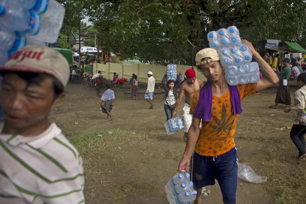 Volunteers load supplies onto boats for flood-affected residents in Ayeyarwady Region in August 2015. Many Myanmar companies focus their CSR activities on donations, including during and after natural disasters. (Ye Aung Thu / AFP)