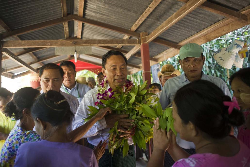 Shwe Mann receives flowers from supporters during an election campaign rally in Phyu Township in 2015. (AFP)