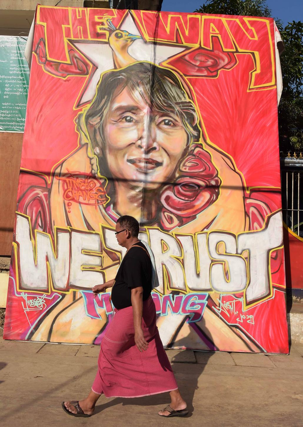 A man walks past a graffiti depiction of Daw Aung San Suu Kyi outside the National League for Democracy headquarters in Yangon on November 13, 2015. (Nicolas Asfouri / AFP)