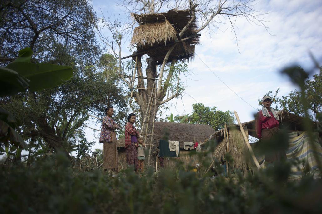 သစ်ပင်ပေါ်မှာ ဆောက်ထားတဲ့ လင့်စင်အိမ်နဲ့အတူ တွေ့ရတဲ့ ဒေသခံမိသားစုတစ်စု။ ဓာတ်ပုံ- အေအက်ဖ်ပီ/ရဲအောင်သူ