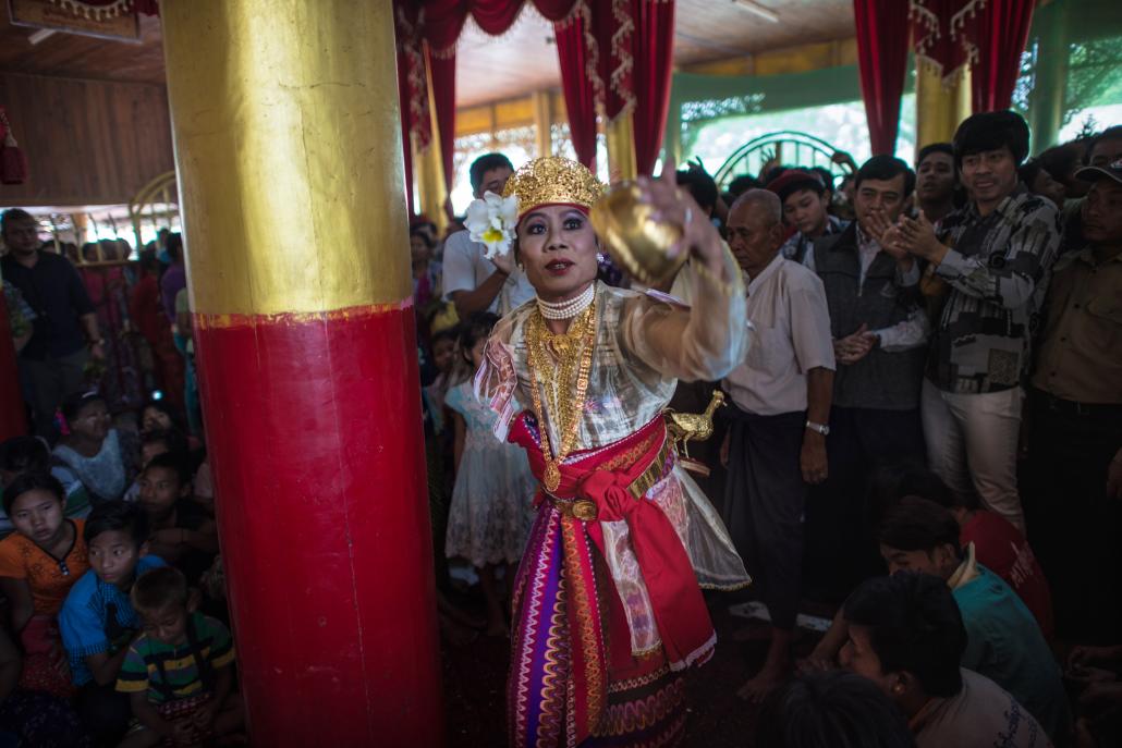 A crowd watches a medium dance as he invokes spirits inside a shrine in Shwe Ku Ni village during the Ko Gyi Kyaw Nat festival on March 7. (Ye Aung Thu | AFP)