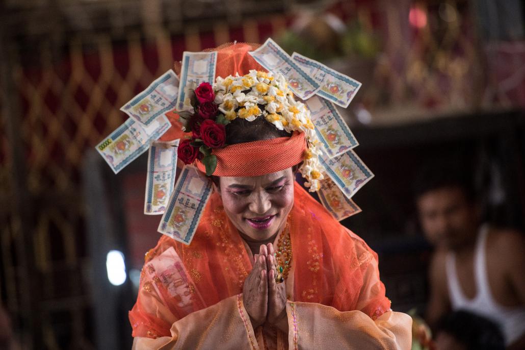 A medium bows before invoking spirits inside a shrine in Shwe Ku Gi village during the Ko Gyi Kyaw Nat festival on March 7. (Ye Aung Thu | AFP)