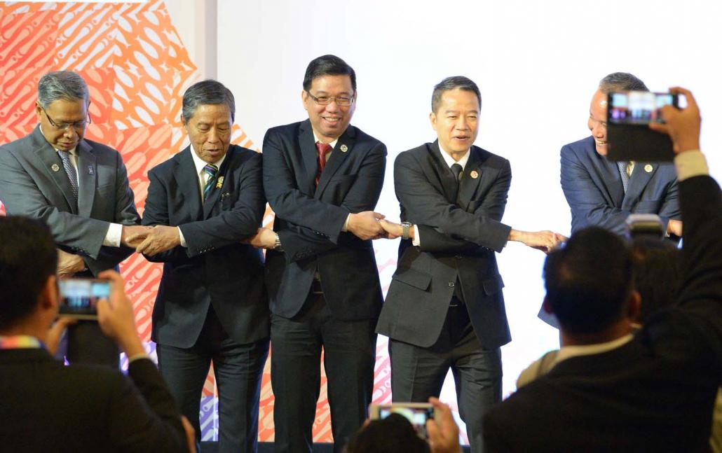 Minister for Planning and Finance U Kyaw Win (second left) holds hands with his counterparts from across the region during the ASEAN Economic Ministers’ meeting in Manila on September 7, 2017. (AFP)