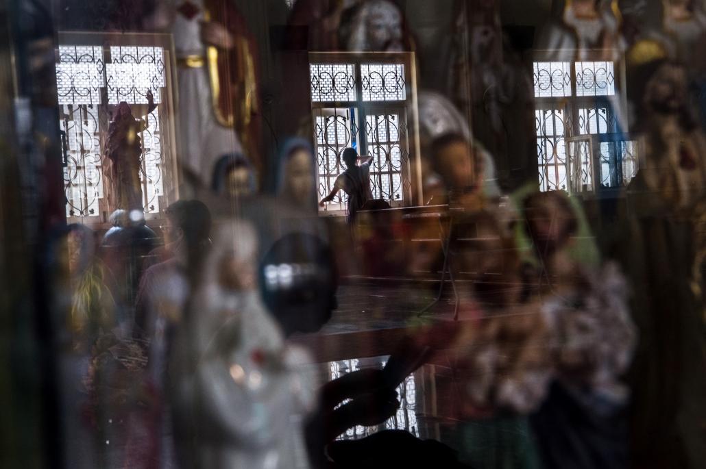 A Karen Catholic devotee closes a window after a Sunday service at the St. Francis Roman Catholic Church in Hpa-an. (AFP)