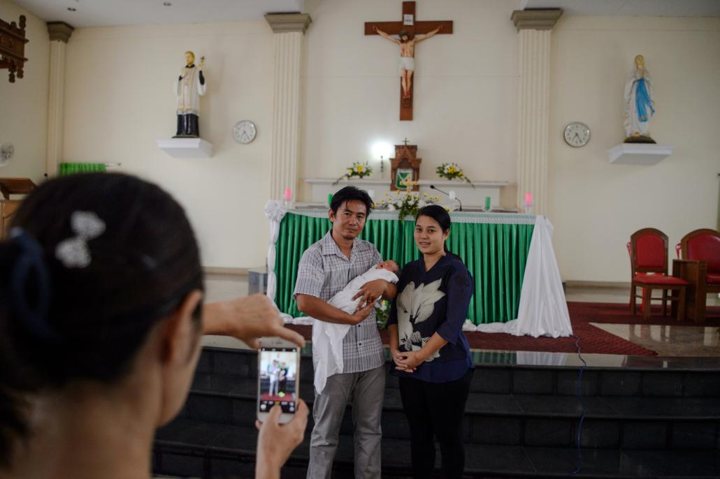 Gregory, 35, and his wife pose for a photo as he carries his newly-Christened one-week-old baby Elias at the St. Francis Roman Catholic Church in Hpa-an, Kayin State. (AFP)