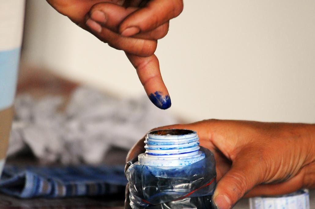 A voter has their fingers inked while casting a ballot in a polling station in Shan State during the 2017 by-elections. (Steve Tickner | Frontier)