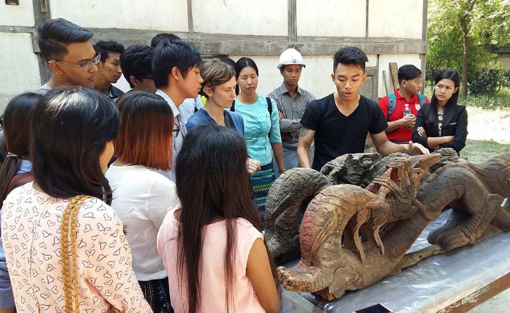 Mandalay civil engineering students learn techniques for excavating, cleaning and restoring a traditional lacquer Toenayar dragon temple ornament. (Supplied)