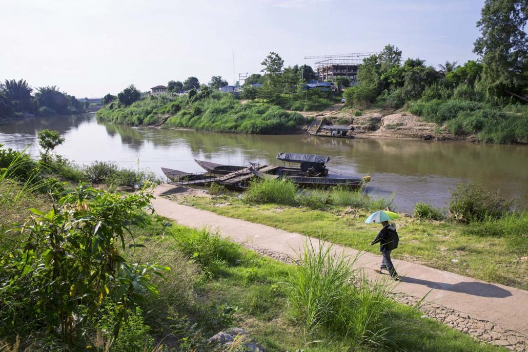 သောင်ရင်း(မိုအီ) မြစ်ကိုဖြတ်မည့်မော်တော်ရှိရာ လျှောက်လှမ်းနေသည့်ဆေးဝန်ထမ်းတစ်ဦး။ ဓာတ်ပုံ - လု(ခ်) ဒပ်ဂယ်ဘီ