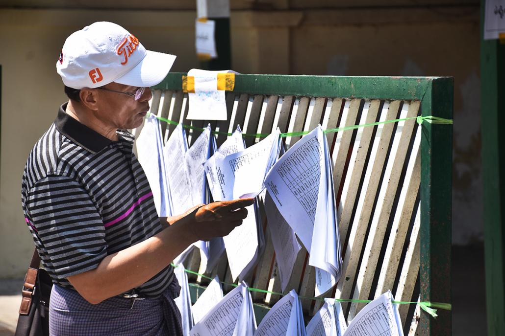 4.	A voter checks for his name on the list outside a polling station in Dagon Township. (Steve Tickner | Frontier)