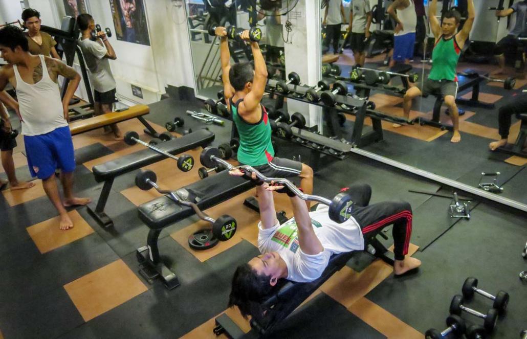 Young men lift weights at Su Myat Fitness Centre in Yangon's South Dagon Township. (Kyaw Lin Htoon | Frontier)