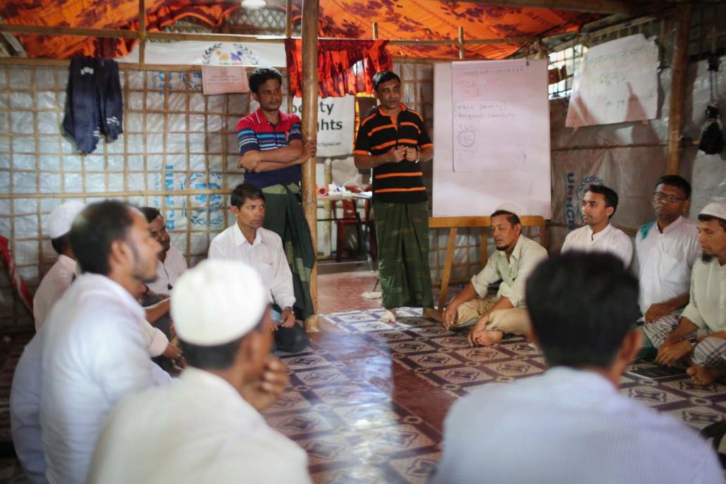 Mohib Ullah, leader of the Arakan Rohingya Society for Peace and Human Rights (standing, right), holds a meeting with other refugees on August 4 to discuss their preconditions for repatriation. (Victoria Milko | Frontier)