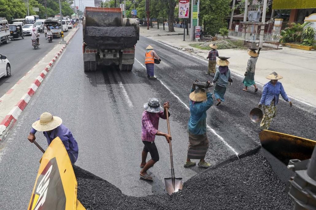 Labourers employed by the MCDC re-surface the Theik Pan road in Mandalay. (Nyein Su Wai Kyaw Soe | Frontier)