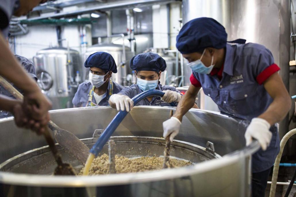 Burbrit workers stir the mash – a mix of malted barley and hot water – in a mash tun. Known as "mashing in", it's the first step in the beermaking process. (Hkun Lat | Frontier)