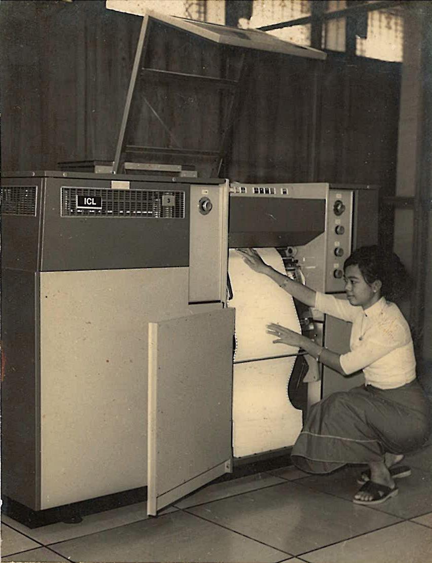 A Universities Computer Centre staff member loads paper into the printer of the ICL 1902S. (Supplied)