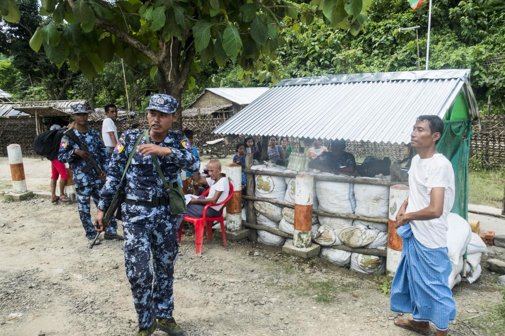 Border Guard Police officers stand guard at a village in Buthdaung Township. (Teza Hlaing | Frontier)