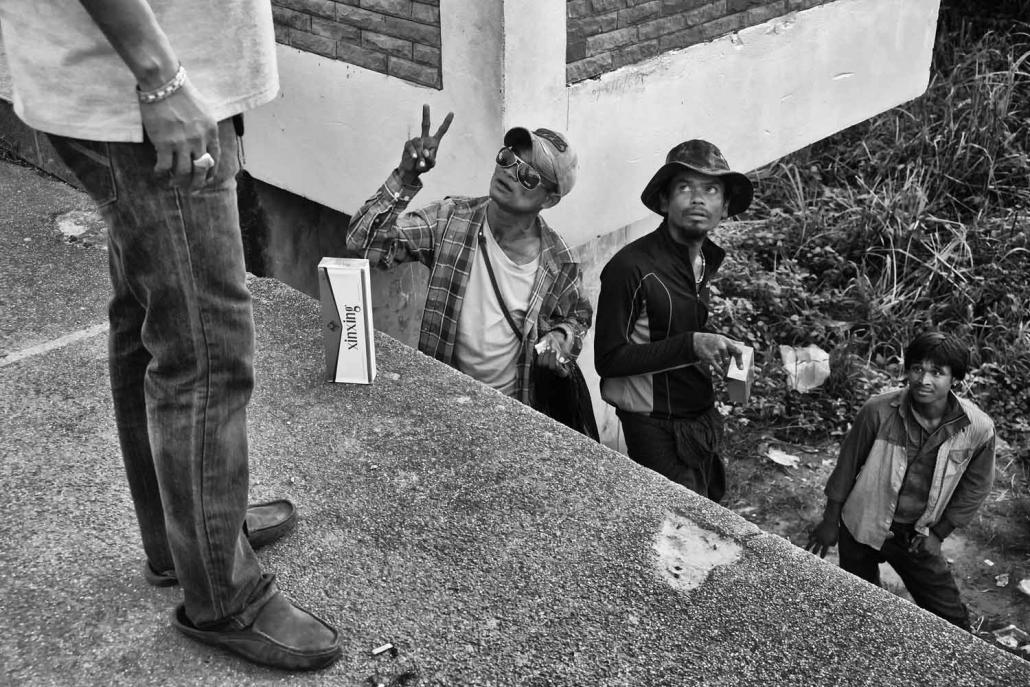 A merchant from "No Man's Land" sells cigarettes to a Thai man standing on the boundaries of the official Thai border. (Brennan O'Connor / Frontier)