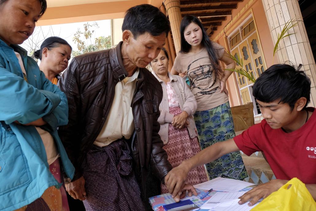 At Aung Su Pan Monastery in Kyaukme, volunteers from the Myitta Society in Lashio take fingerprints before donating basic amenities to displaced villagers. (Brennan O'Connor / Frontier)