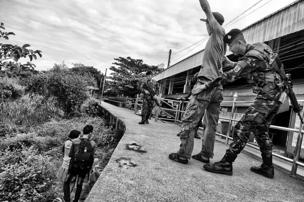 Thai soldiers conduct searches on migrant workers entering Thailand at Mae Sot from Myawaddy in Myanmar at one of the unofficial crossing points along the border. (Brennan O'Connor / Frontier)