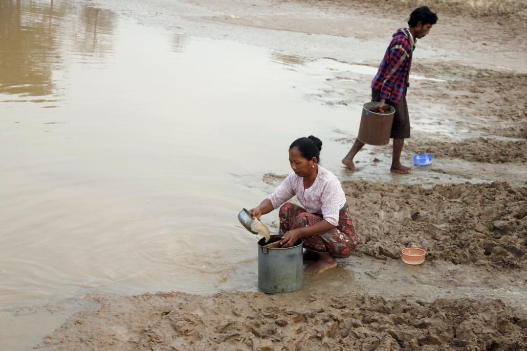 Villagers fill up water buckets at a pond in Kyaukpadaung Township, Magway Region. (Teza Hlaing / Frontier)