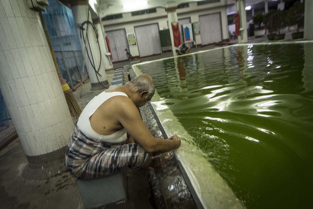 A man cleans his hands before attending Friday prayers at Taung Balu mosque in Mandalay (Teza Hlaing | Frontier)