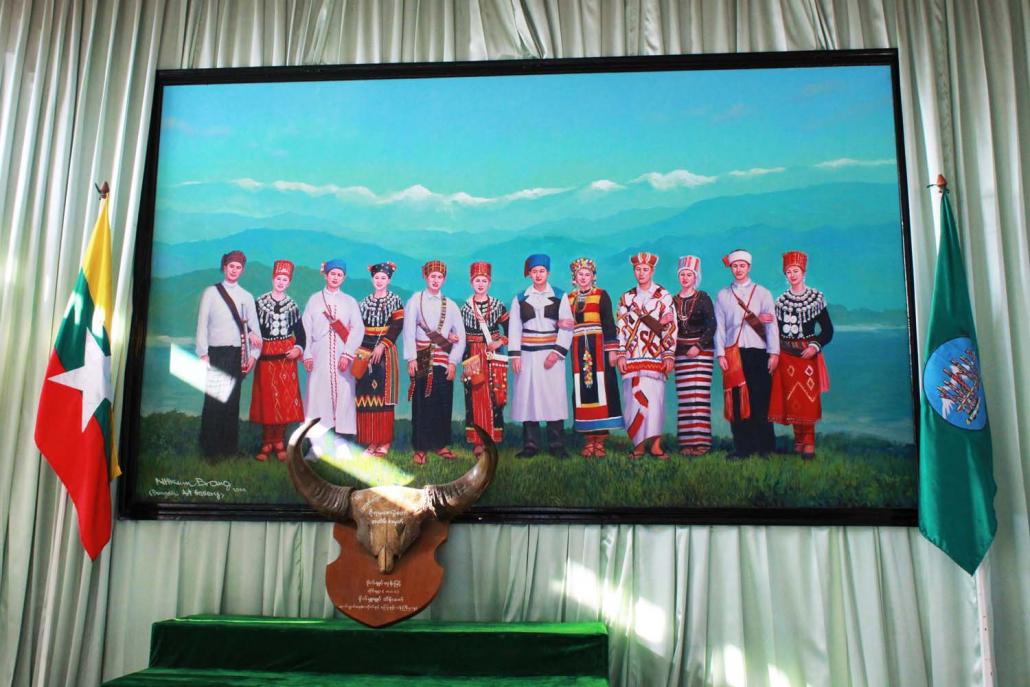 A painting representing six Kachin ethnic groups in their traditional dress hangs in the Myitkyina office of the Kachin National Association of Tradition and Culture. (Emily Fishbein | Frontier)