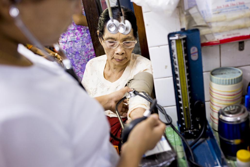 ရန်ကုန် ပန်းဘဲတန်းမြို့နယ်ရှိ အေးရိပ်သာဆေးခန်းတွင် ဆရာဝန်တစ်ဦးက လူနာတစ်ဦးကို စမ်းသပ်စစ်ဆေးနေစဉ်။ ဓာတ်ပုံ - အန်းဝမ်