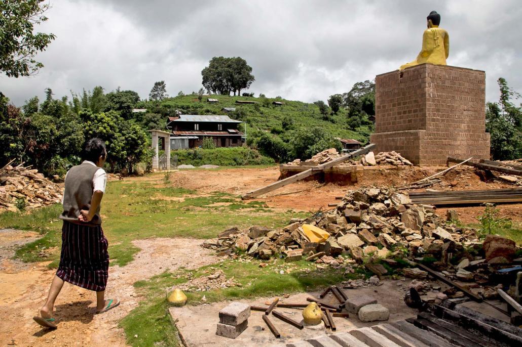 တော့ဆန်ကျေးရွာက အပျက်အစီးတွေကြားထဲ ဖြတ်လျောက်နေတဲ့ ရွာသားတစ်ဦး။ ဓာတ်ပုံ-အန်းဝမ်