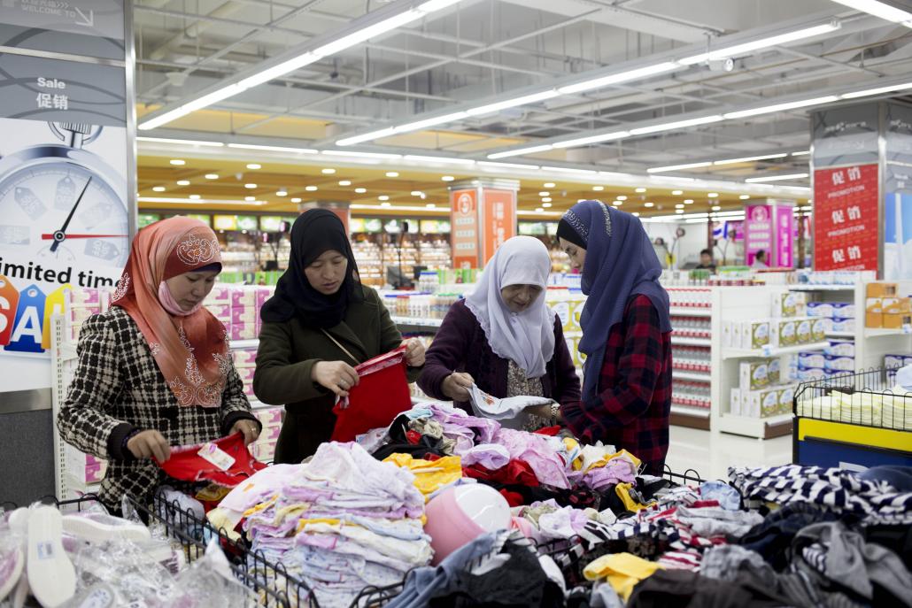 A Huan shops for clothes with friends at a shopping mall in Ruili. (Ann Wang / Frontier)