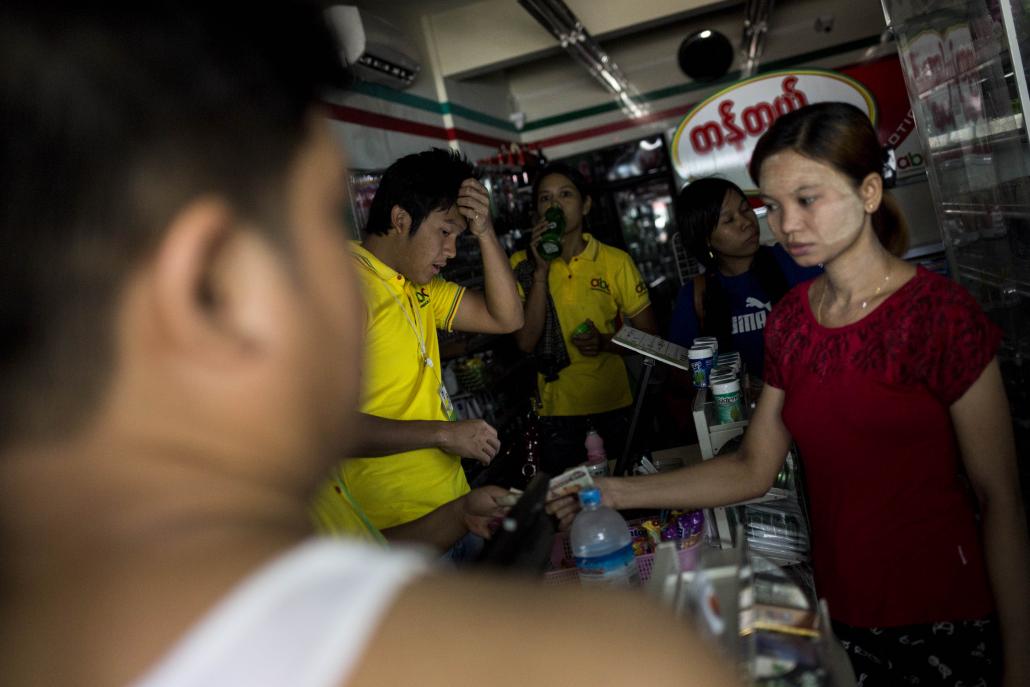 Customers and staff struggle with the heat during another blackout at a convenience store in Yangon. (Ann Wang / Frontier)