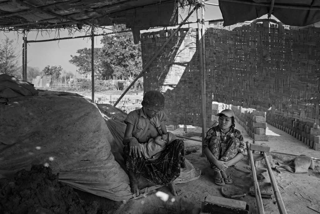 Ma Than Nwe, left, feeds her young daughter. She arrived at the Hlegu brick kiln 15 years ago with U Naing Lin from the Ayeyarwady Delta (Andre Malerba | Frontier)