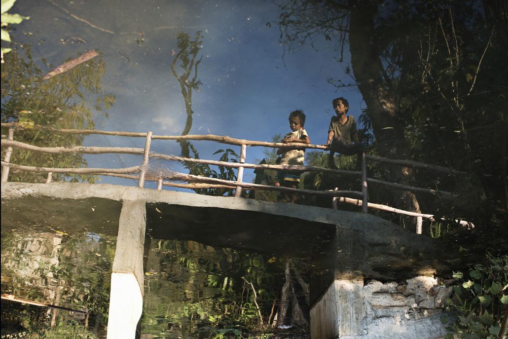 Children reflected in a pond at the Mae La Oon refugee camp. (Vincenzo Floramo / Frontier)