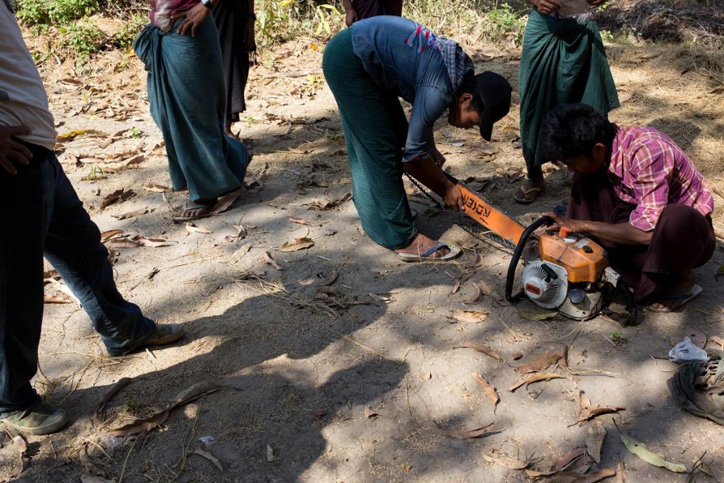 Altered to an inspection by the Forestry Department, villagers from Mahu take a chainsaw apart to hide parts in different locations in the forest. (Ann Wang | Mongabay)