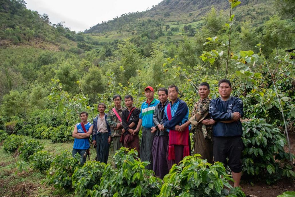 Coffee farmers in Bant Sawk, Hopong Township, hold hands with Khun Ye Hlaing (third right), who leads the Indigo Mountain cooperative established with support from Winrock. (Rajiv Raman | Frontier)