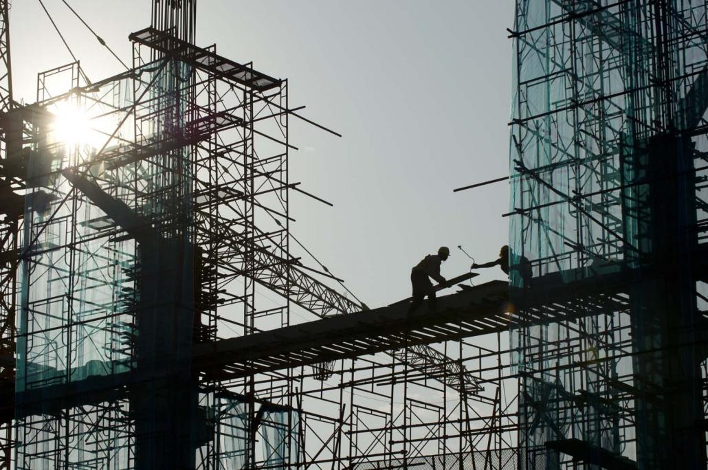 Labourers work at a construction site in Yangon. The Central Bank's mismanagement of the banking sector has diverted scarce financial resources into real estate speculation. (AFP)