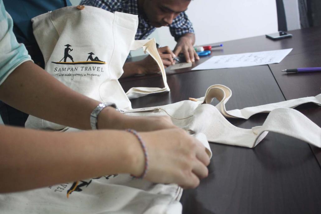 Sampan staff prepare bags for clients that contain souvenirs made from waste from the company's head office. (Supplied)