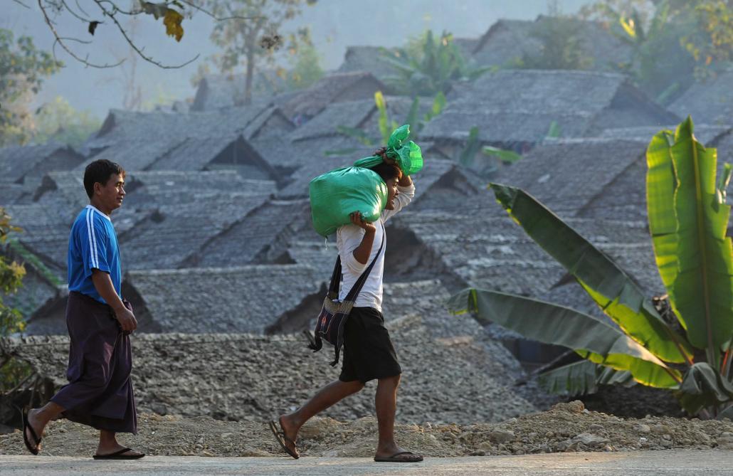 ၂၀၁၂ ဇန်နဝါရီလအတွင်းက ထိုင်း-မြန်မာနယ်စပ်အနီးရှိ မဲဆောက်မြို့ မယ်လဒုက္ခသည်စခန်းမှ ယာယီတဲတန်းကို ဖြတ်သန်းသွားလာနေသည့် ကရင်ဒုက္ခသည်အချို့ကို တွေ့ရစဉ်။ ဓာတ်ပုံ - အေအက်ဖ်ပီ