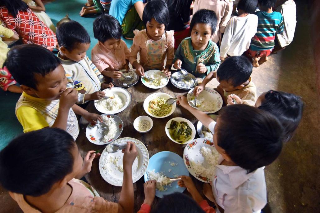 Children displaced by recent fighting in northern Shan State eat at a monastery in Kutkai Township. (Steve Tickner | Frontier)